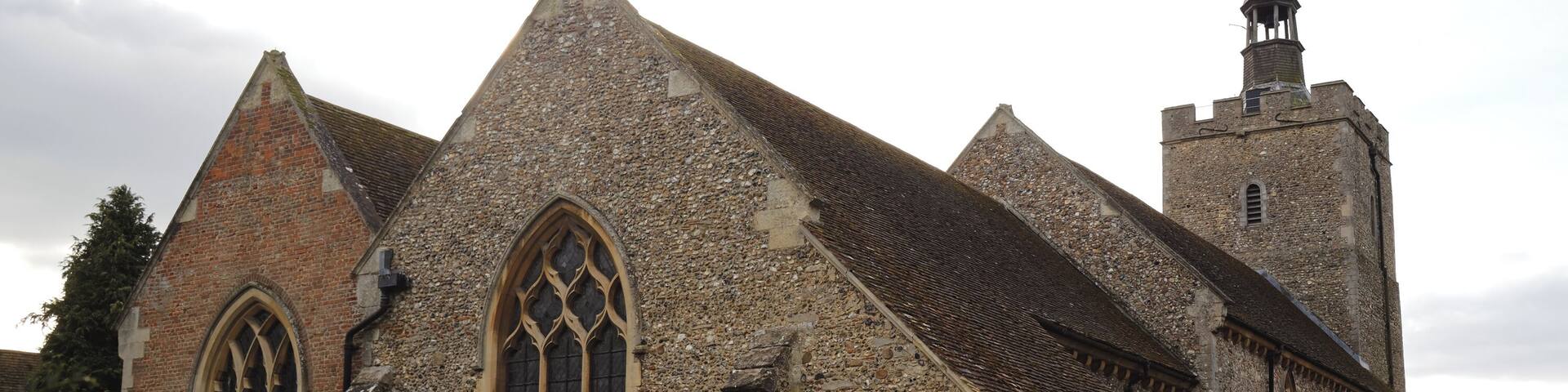 A historic church with a stone facade, large arched windows, and a bell tower.