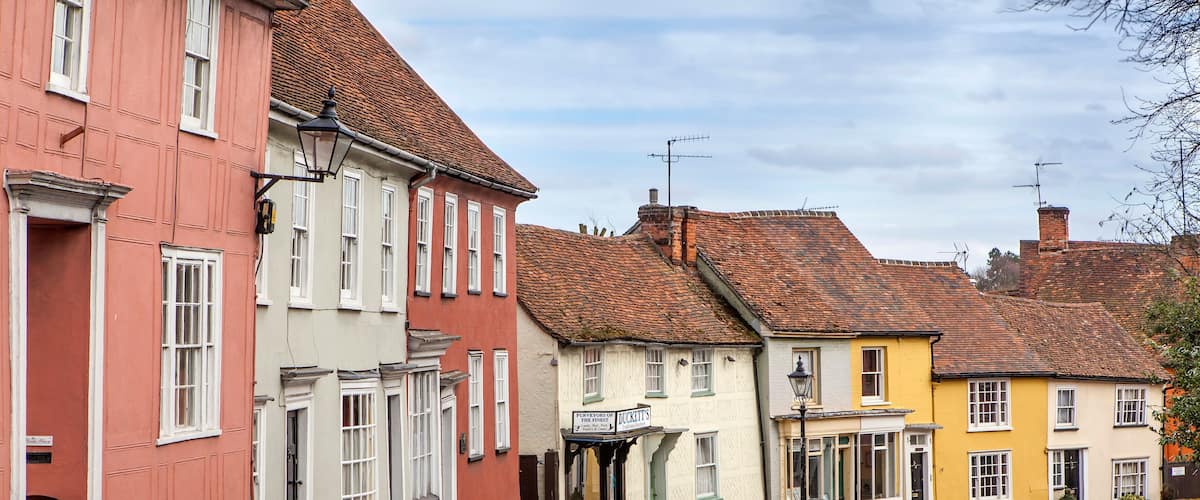 A narrow street lined with colorful buildings, including a pub named 'The Olde Coach.'