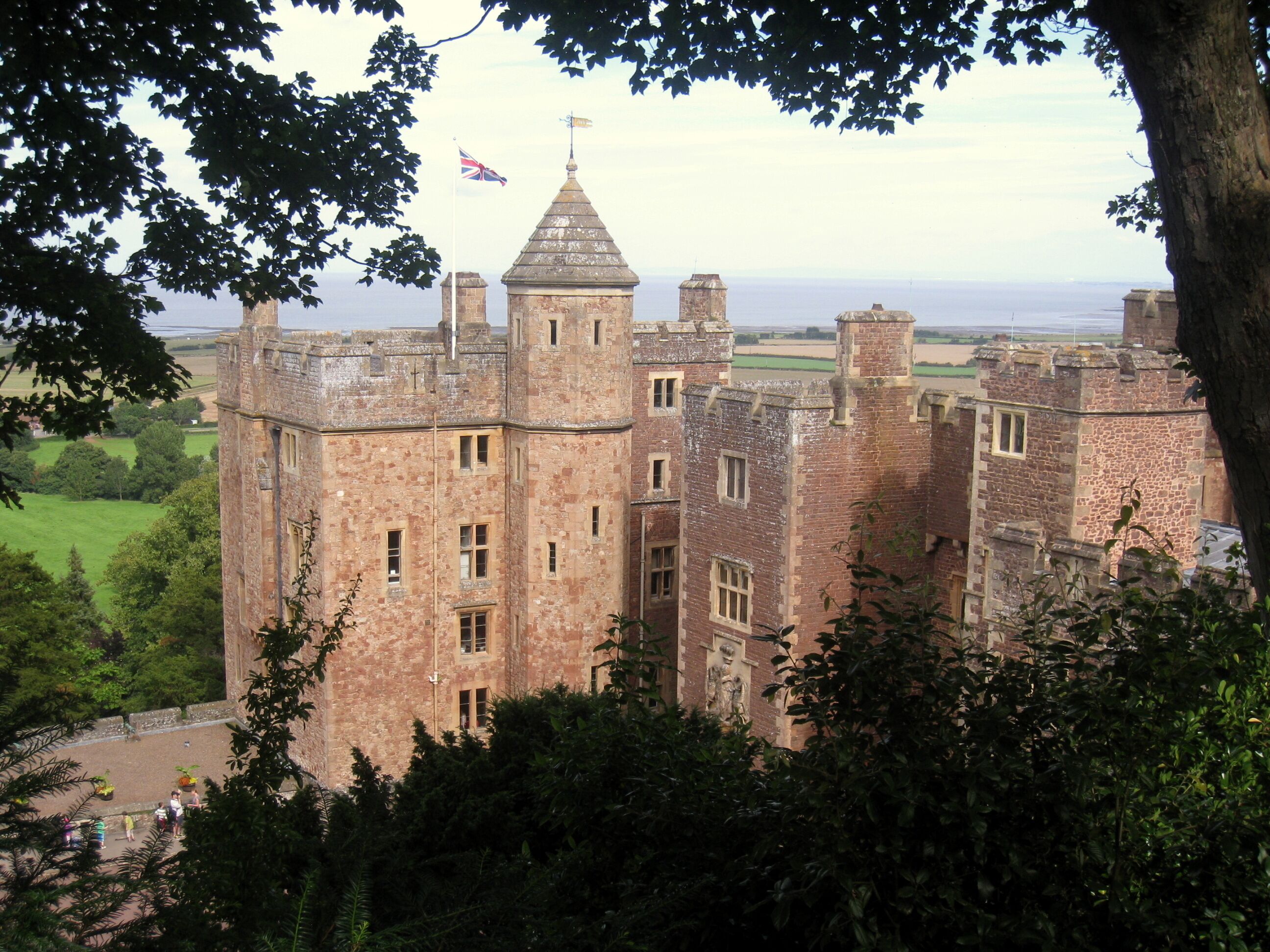 A historic castle with multiple towers and a flag.