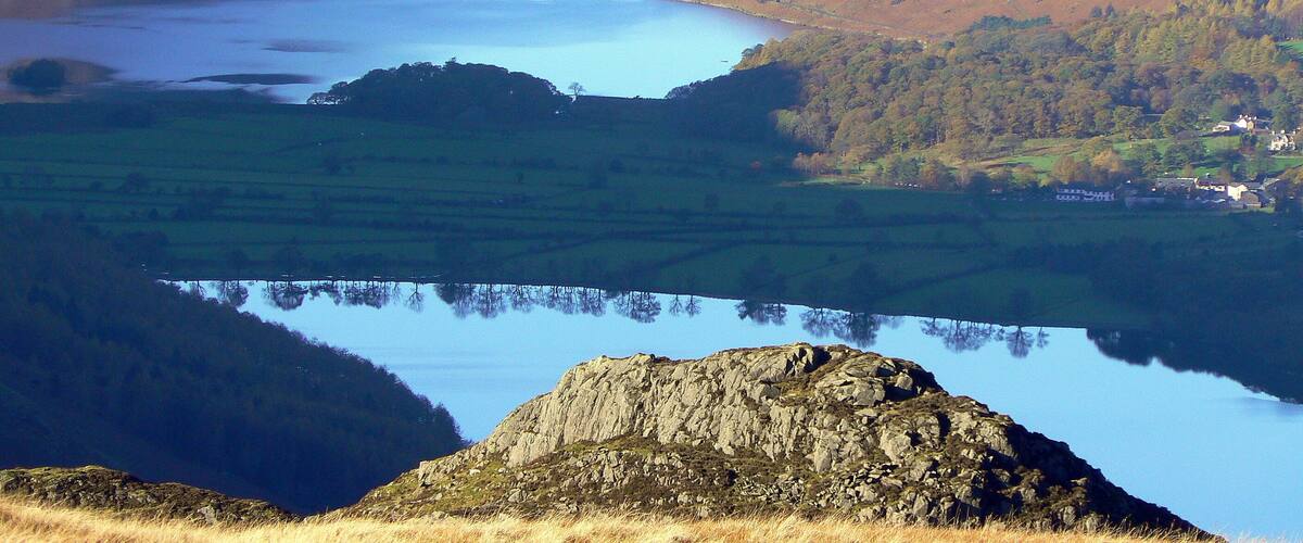 Un lago rodeado de montañas y campos.