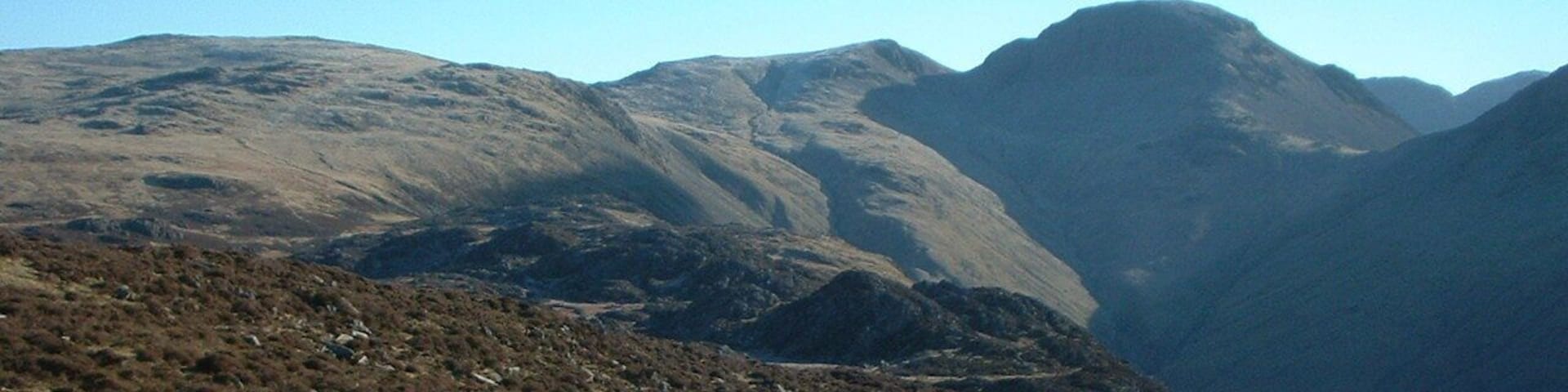 Un paisaje montañoso y agreste con terreno rocoso y vegetación escasa.
