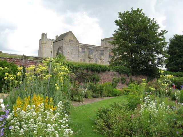 A historic stone building with a garden in front.