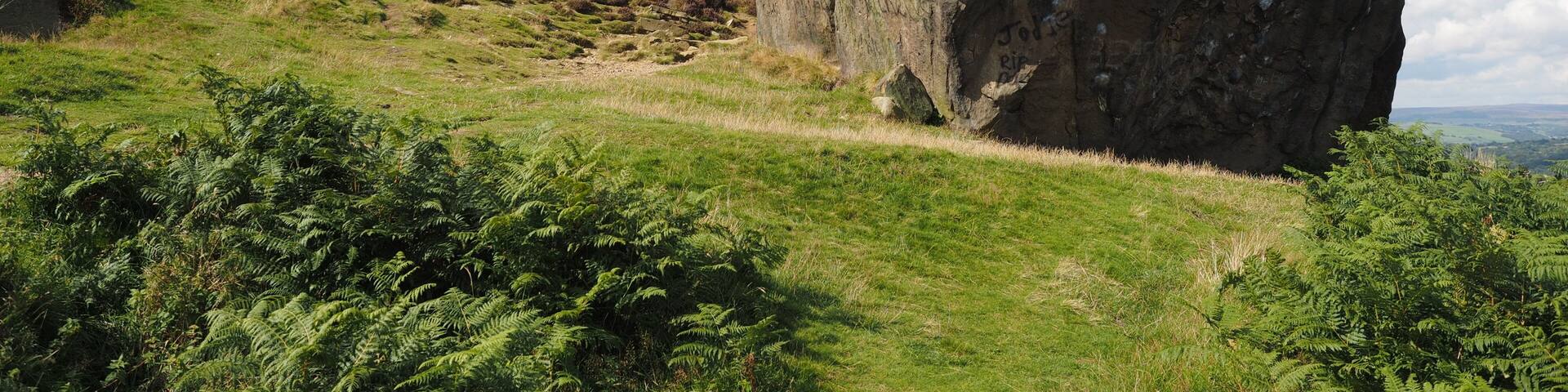 A large rock formation with a path leading up to it.