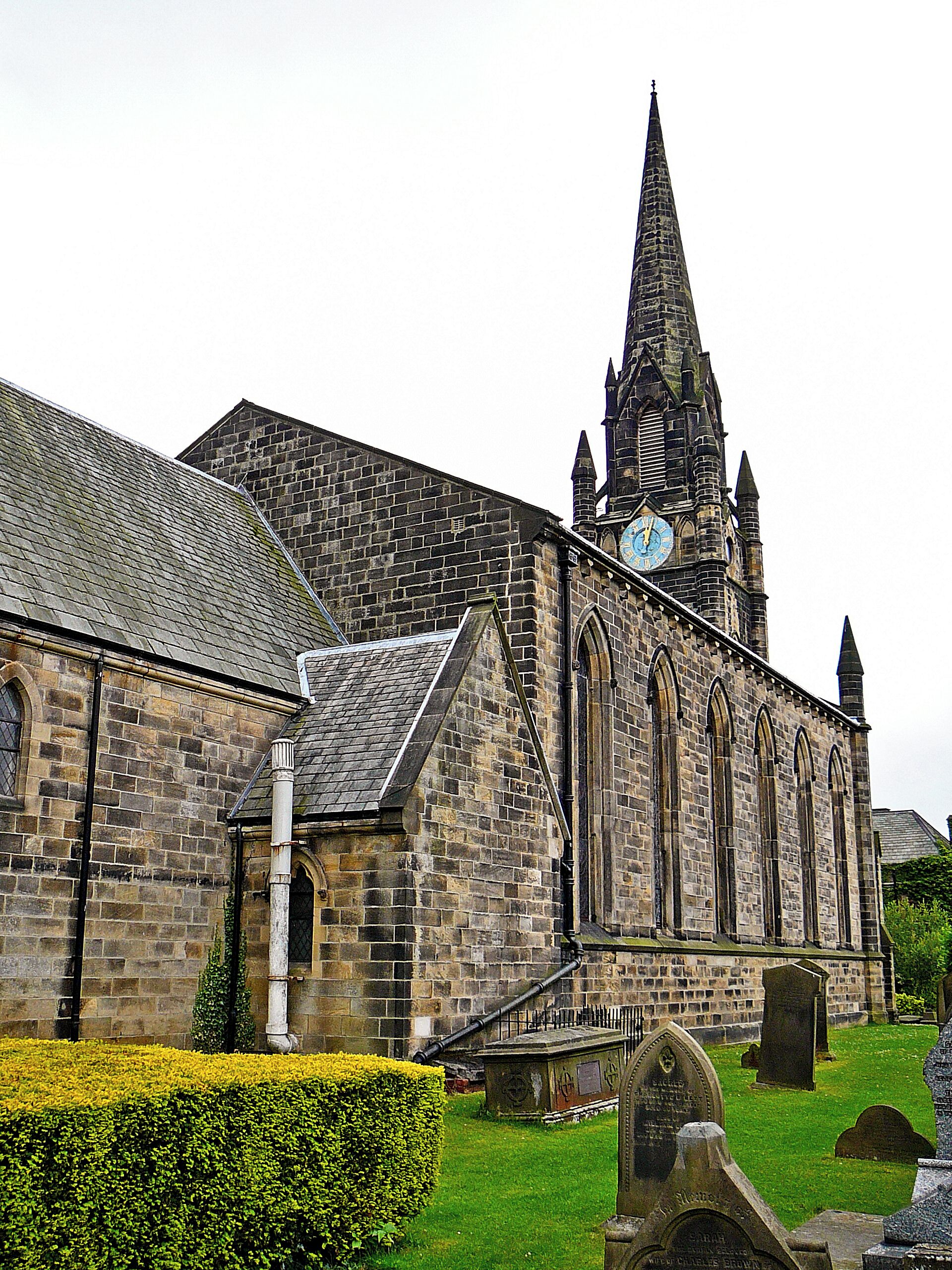 A historic church with a tall spire and a clock tower.