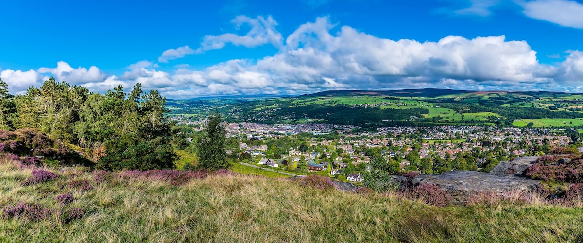 A town nestled in a valley with rolling hills and a clear blue sky.