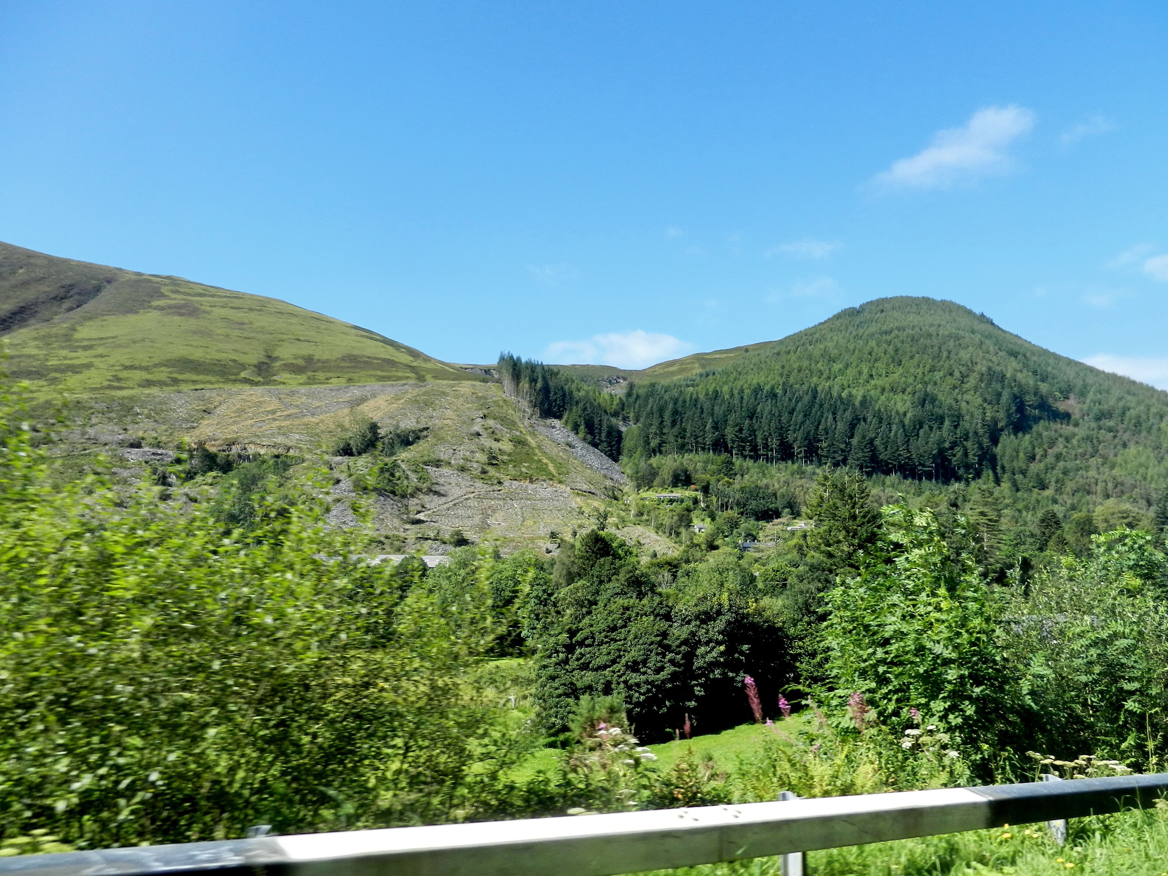 A mountainous landscape with lush greenery and a clear blue sky.