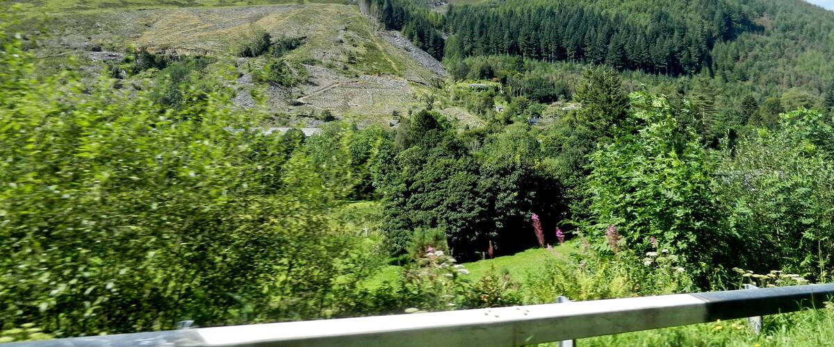 A mountainous landscape with lush greenery and a clear blue sky.