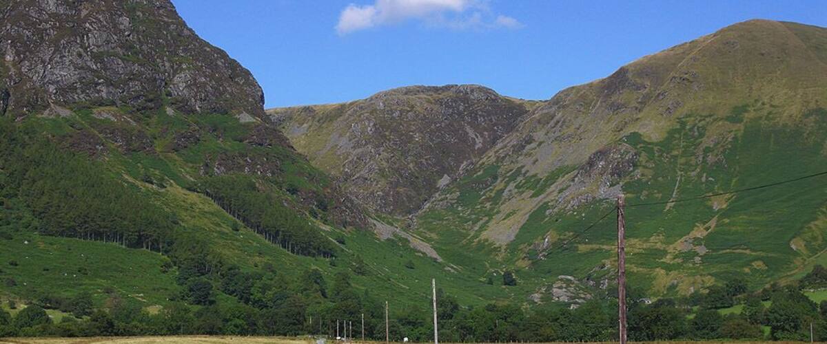 Cwm Cywarch Caught between summer and autumn; the bracken is still a vibrant green but the heather is in full bloom. The flat floor of the cwm contrasts with the great crag of Craig Cywarch on the left, known to connoisseurs of rock climbing.