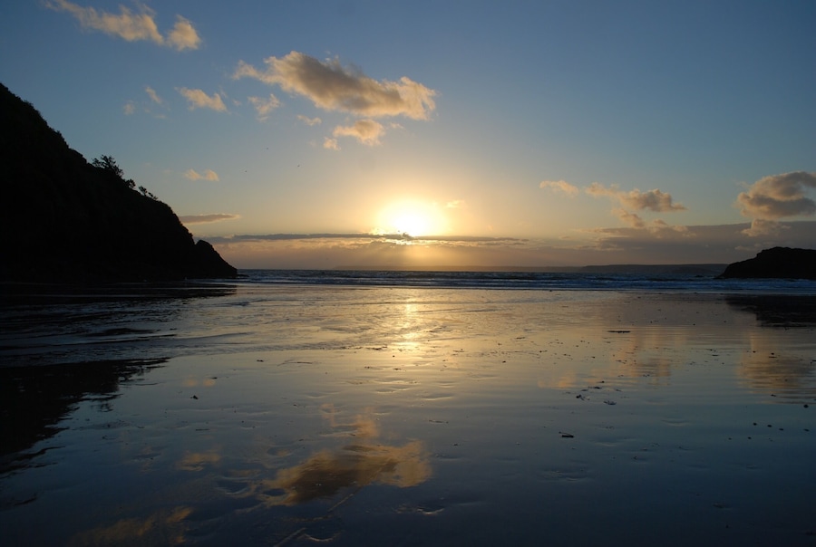 Sun setting over Plymouth from Hope Cove Beach.