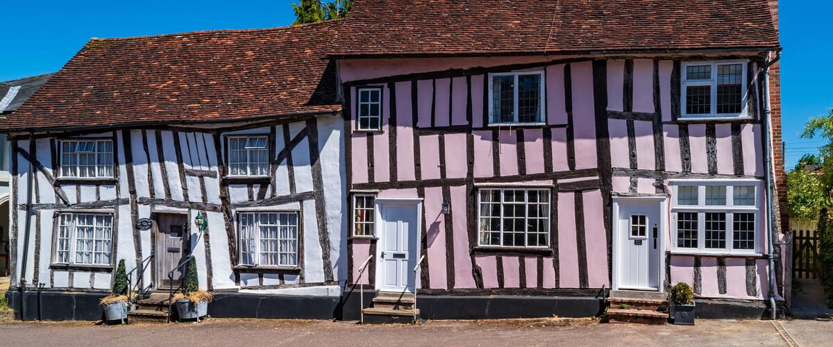 A traditional half-timbered house with a red-tiled roof and white walls.
