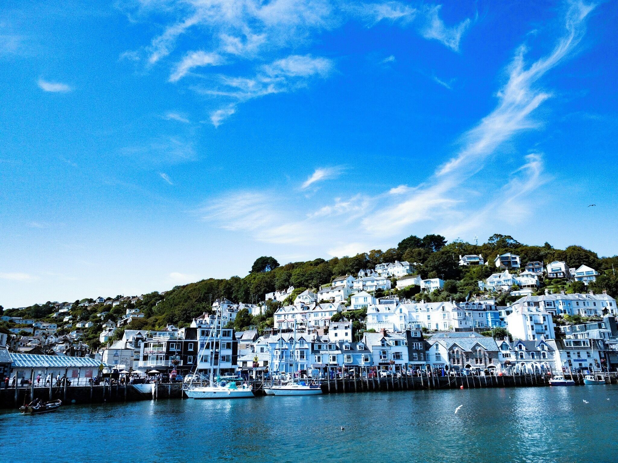 A coastal town with white buildings, a pier, and boats.
