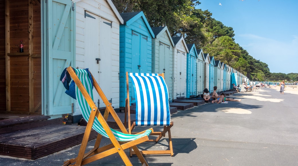 Folding deck chairs sat outside a line of beach huts on Avon Beach at Mudeford in Dorset, UK