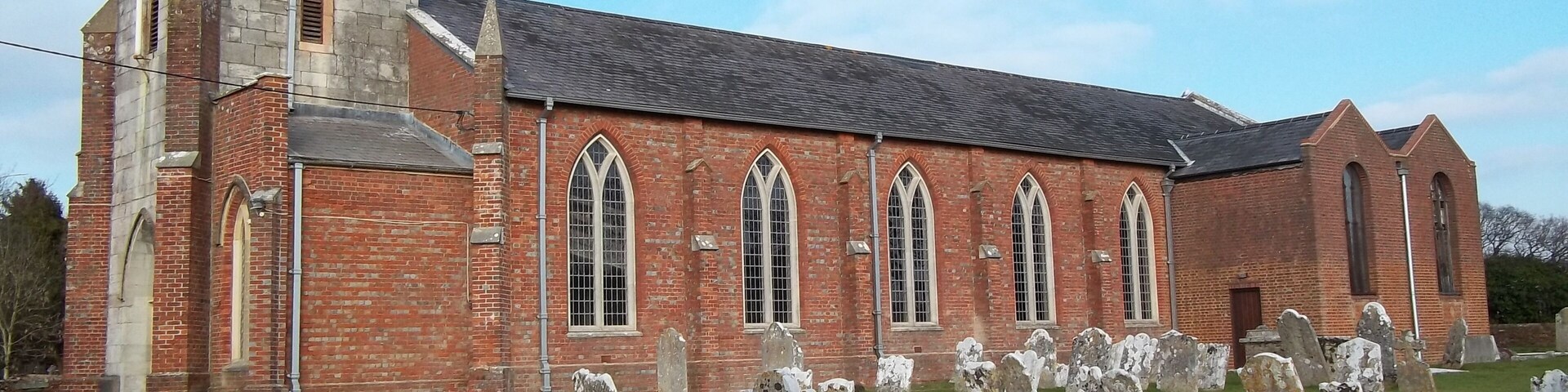 St Mary Magdalene parish church, New Milton, Hampshire, seen from the southwest. The stone tower is 17th-century; the brick nave and buttresses were completed in 1832, and the lady chapel (right) was added in 1958.