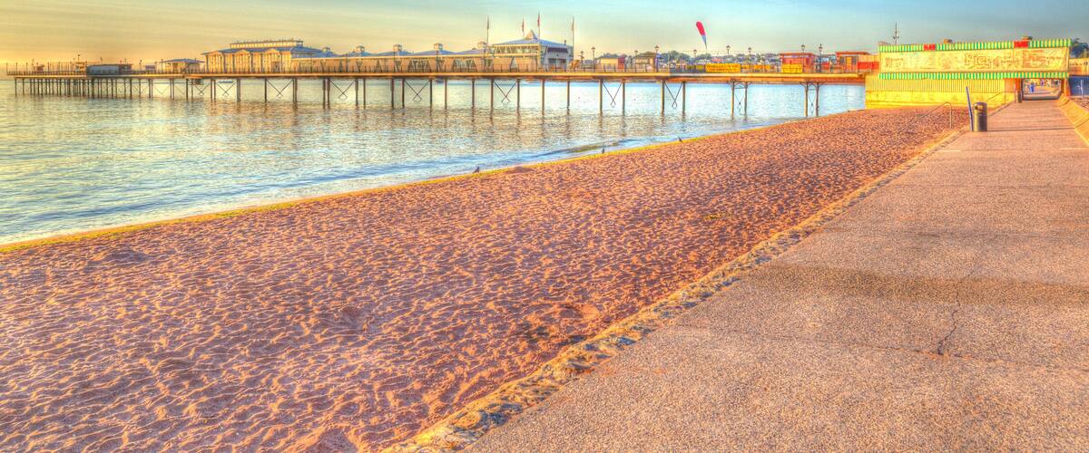 DE6GTK Paignton pier and sandy beach Torbay Devon England in HDR with blue sky, near tourist destinations of Torquay and Brixham
