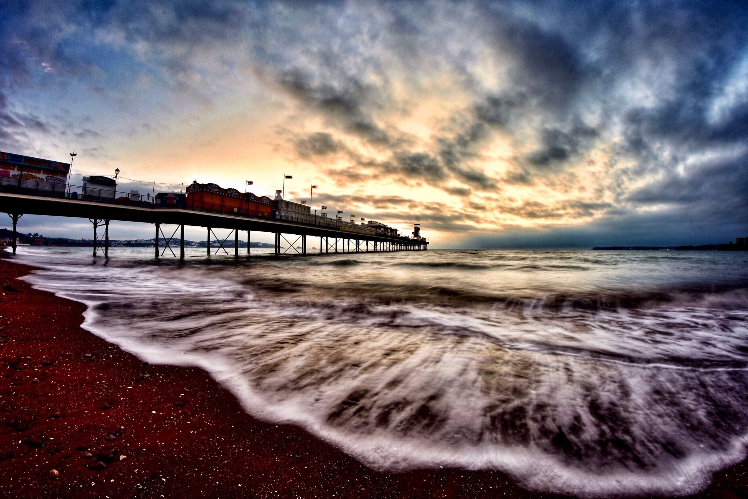 Paignton Pier in the English Riviera before sunrise. Taken with a Nikon camera and fisheye lens.