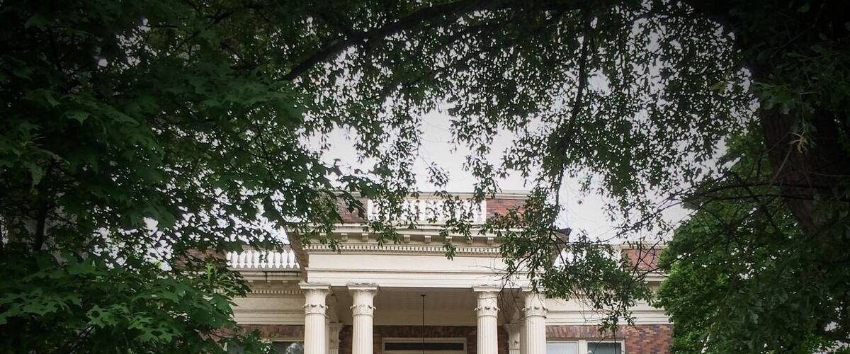 Completed in 1910, the Herndon Home, was the residence of Alonzo Herndon and his family. Herdon was a former slave raised in a sharecropping family after the Civil War. Herndon studied barbering, and owned and managed a string of barbershops in downtown Atlanta after the Civil War, one of which was considered to be the most elegant in the country with marble floors and chandelier. Investing his income into real estate, Herndon became the largest black property owner in Atlanta by 1900. Later, Herndon founded the Atlanta Life Insurance Company, located in the Sweet Auburn Historic District, and became Atlanta's first black millionaire. The home was primarily designed by Adrienne Herndon, Alonzo's first wife and a teacher at Atlanta University. The couple had one son, Norris. Adrienne died of Addison's disease just three months after the home was completed. In 1912 Alonzo married Jessie Gillespie.
The Herndon home is a two-story, 15-room Beaux Arts mansion built by local black craftsmen. The formally composed building is constructed with multi-colored brick, and features a two-story entry portico supported by Corinthian columns. One-story porches to each side of the building echo this theme in brick piers and wooden capitals. An elliptical fanlight over the main entrance and the balustrade above the full entablature of the building's cornice add a distinctly Georgian Revival flavor to this imposing residence. The Herndon Home is a lasting tribute to the hard work and talent of extraordinary African Americans in Atlanta, and was designated a National Historic Landmark in 2000.