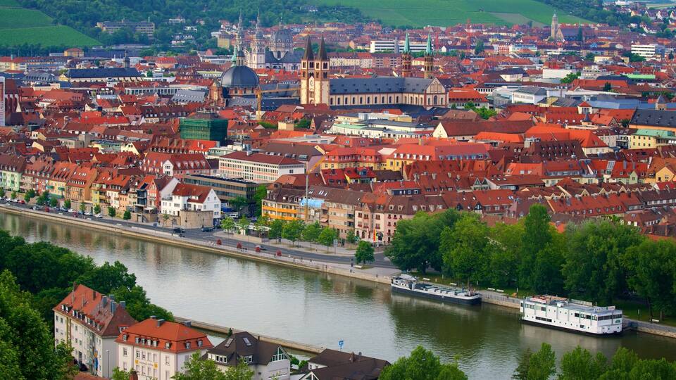 A river with a boat, surrounded by colorful buildings and a prominent church tower.
