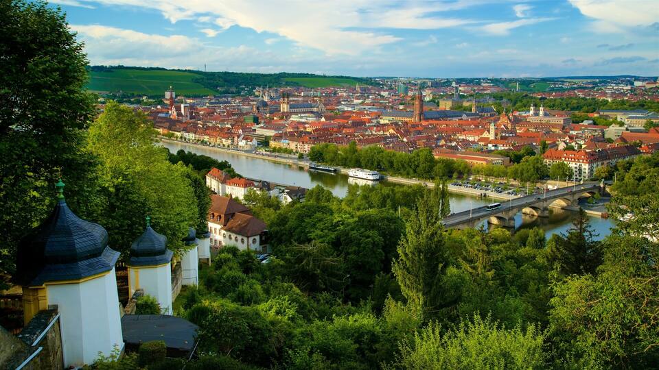 A river flowing through a city with red-roofed buildings and a bridge.