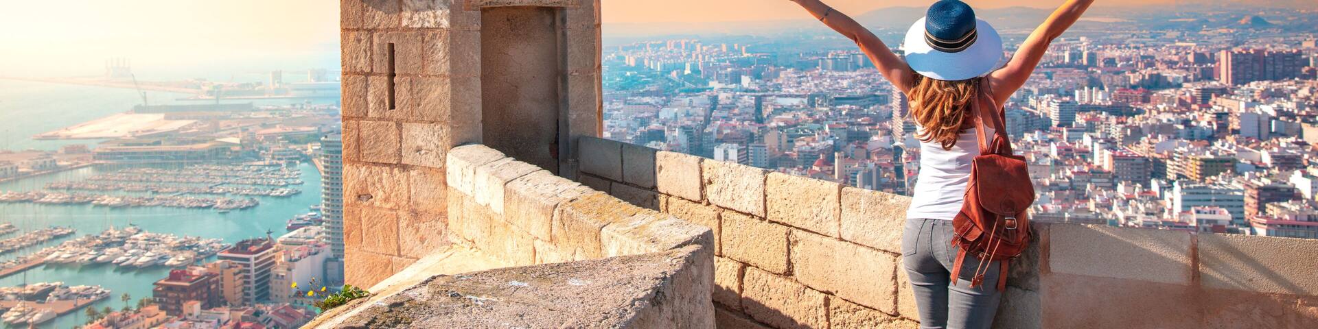 Alicante Santa Barbara castle in Costa Blanca, happy woman tourist looking at panoramic city landscape view