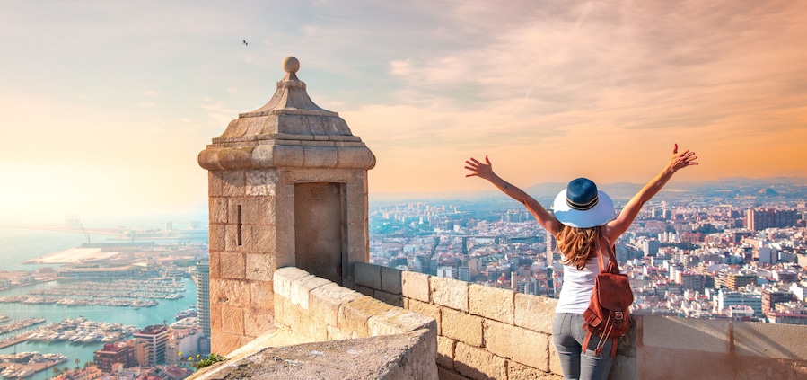 Alicante Santa Barbara castle in Costa Blanca, happy woman tourist looking at panoramic city landscape view