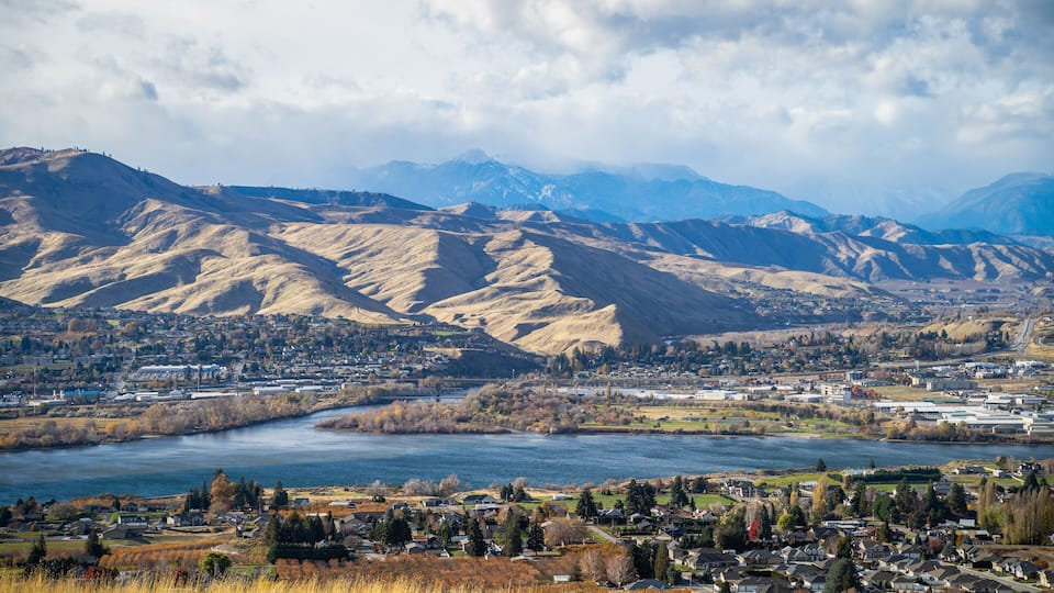 A town nestled between mountains and a river.