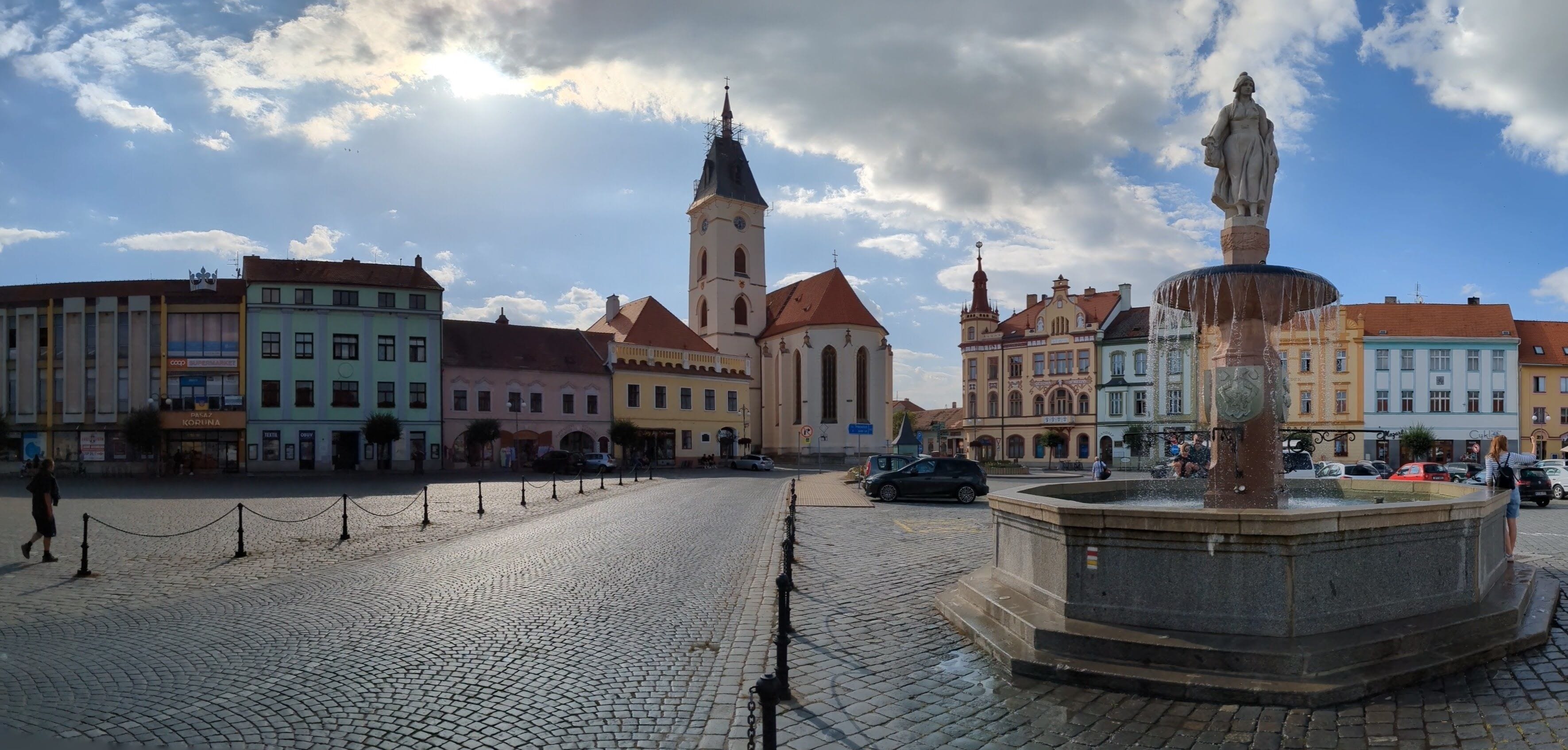 Vodnany historical old town square with fountain,column and his bohemian architecture, surrounding streets and church with tower.Bohemia,Czechia,European union