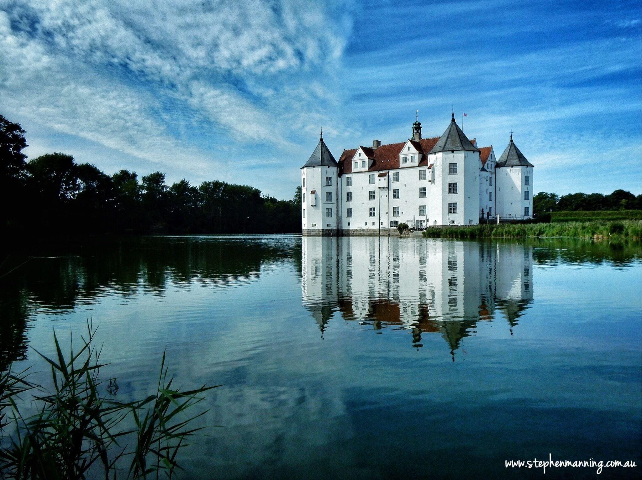 Schloss Glucksburg is a castle in northern Germany very close to the border with Denmark, construction of which was completed in 1587 on the site of a former monastery. 

The castle is completely surrounded by water except for the entry road and makes a wonderful photogenic subject with it high white washed walls, red roof, corner towers and the reflections in the water. 

We didn't go inside through due to the time we had available, unfortunately. The admission price was €8 per person and parking €2 for three hours out the front. #blue
#bestof5