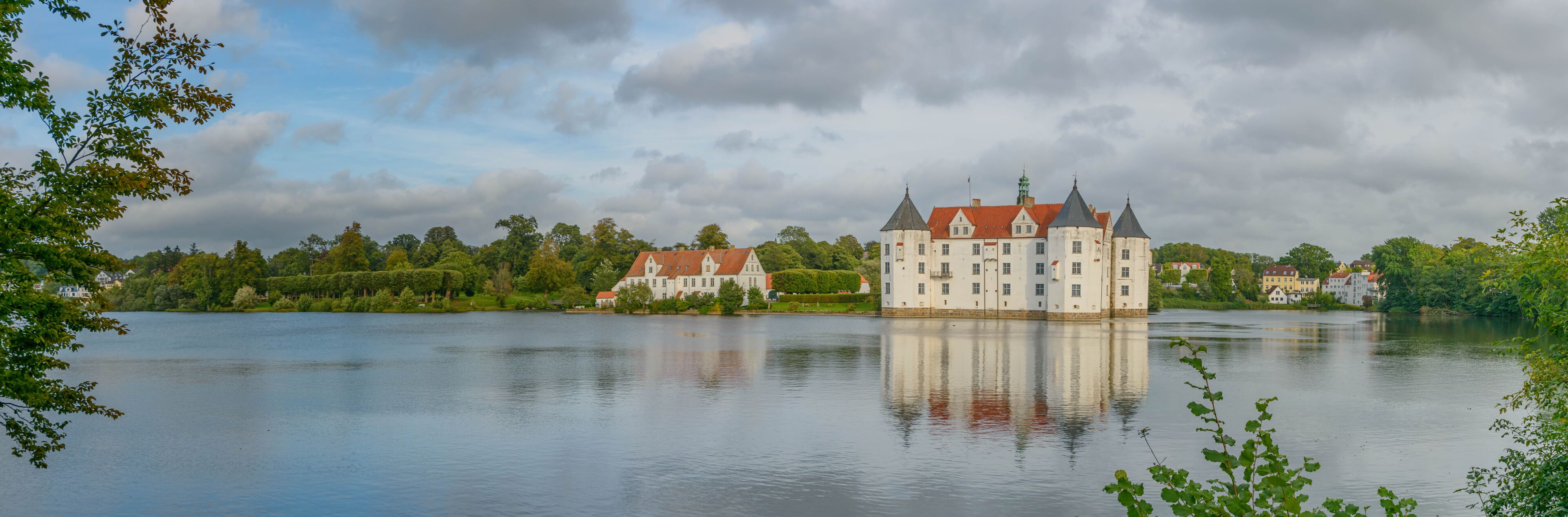 View of water castle Glücksburg on the Flensburg Fjord in the town of Glücksburg, Schleswig-Holstein, Germany. Renaissance castle on the lake in Glucksburg.
