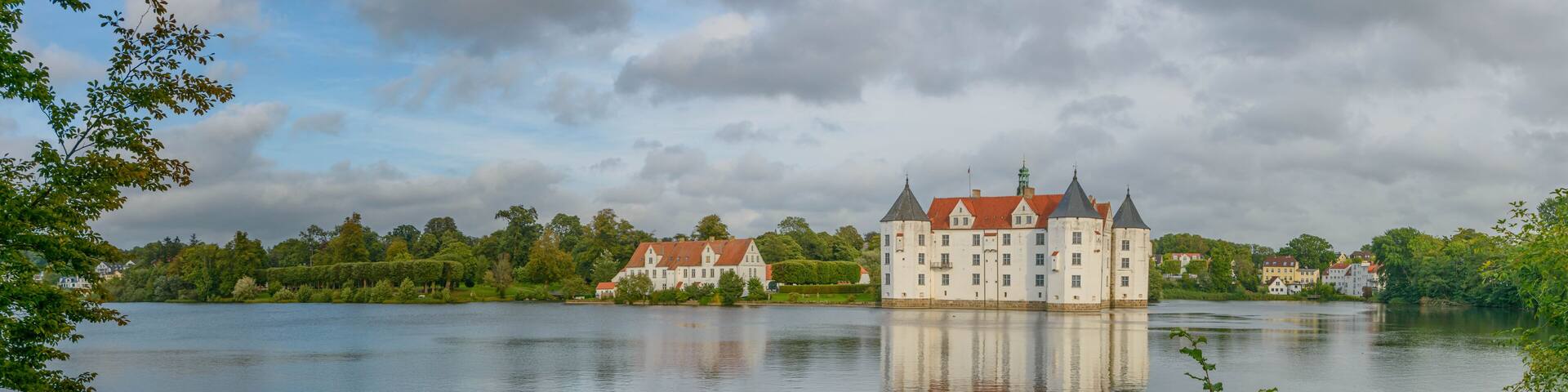 View of water castle GlĂŒcksburg on the Flensburg Fjord in the town of GlĂŒcksburg, Schleswig-Holstein, Germany. Renaissance castle on the lake in Glucksburg.