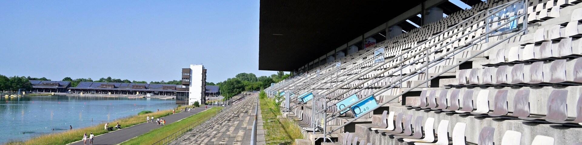 Estádio com cadeiras vazias e vista para um rio.