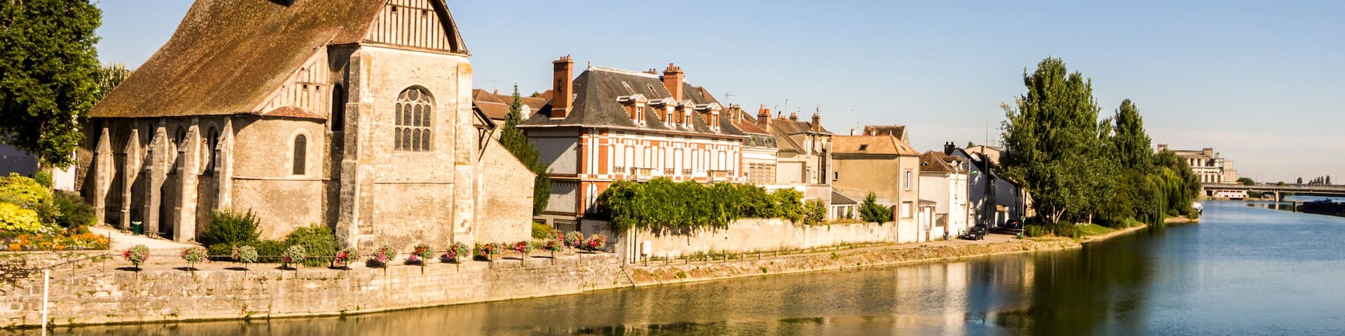 The Catholic church of Saint-Maurice in Sens, Burgundy, France, reflected in the river Yonne