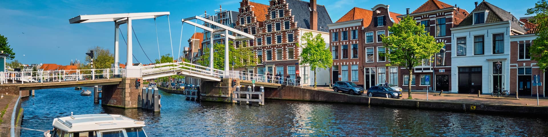 Spaarne river with boat and Gravestenenbrug bridge in Haarlem, N
