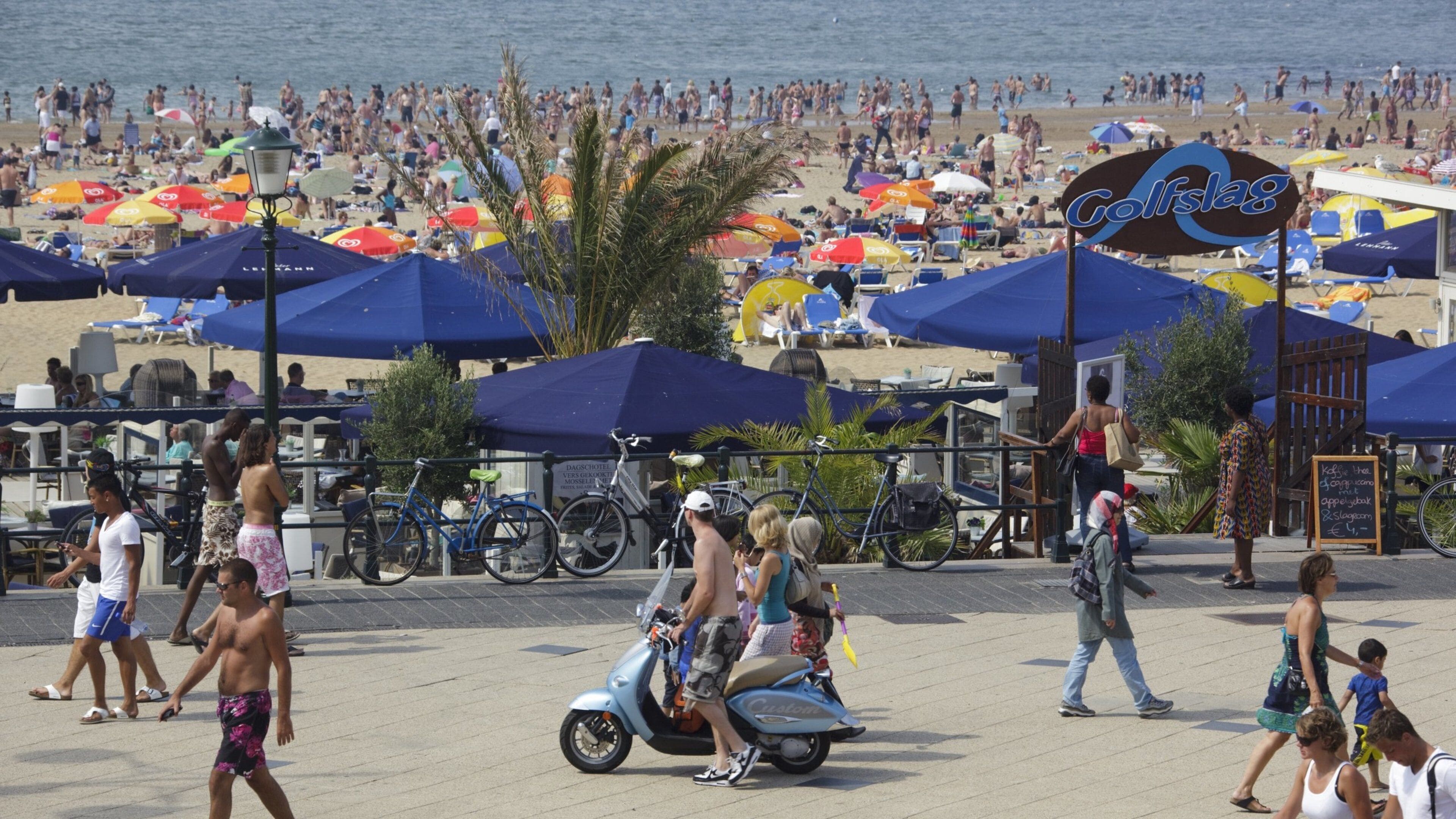 Scheveningen-Strand das einen Straßenszenen, Sandstrand und Mopedfahren