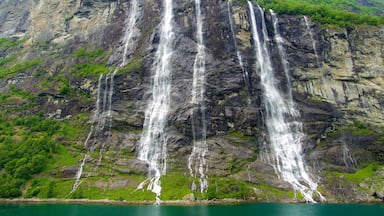 Una cascada de varios niveles que se precipita por un acantilado rocoso, rodeada de abundante vegetación.