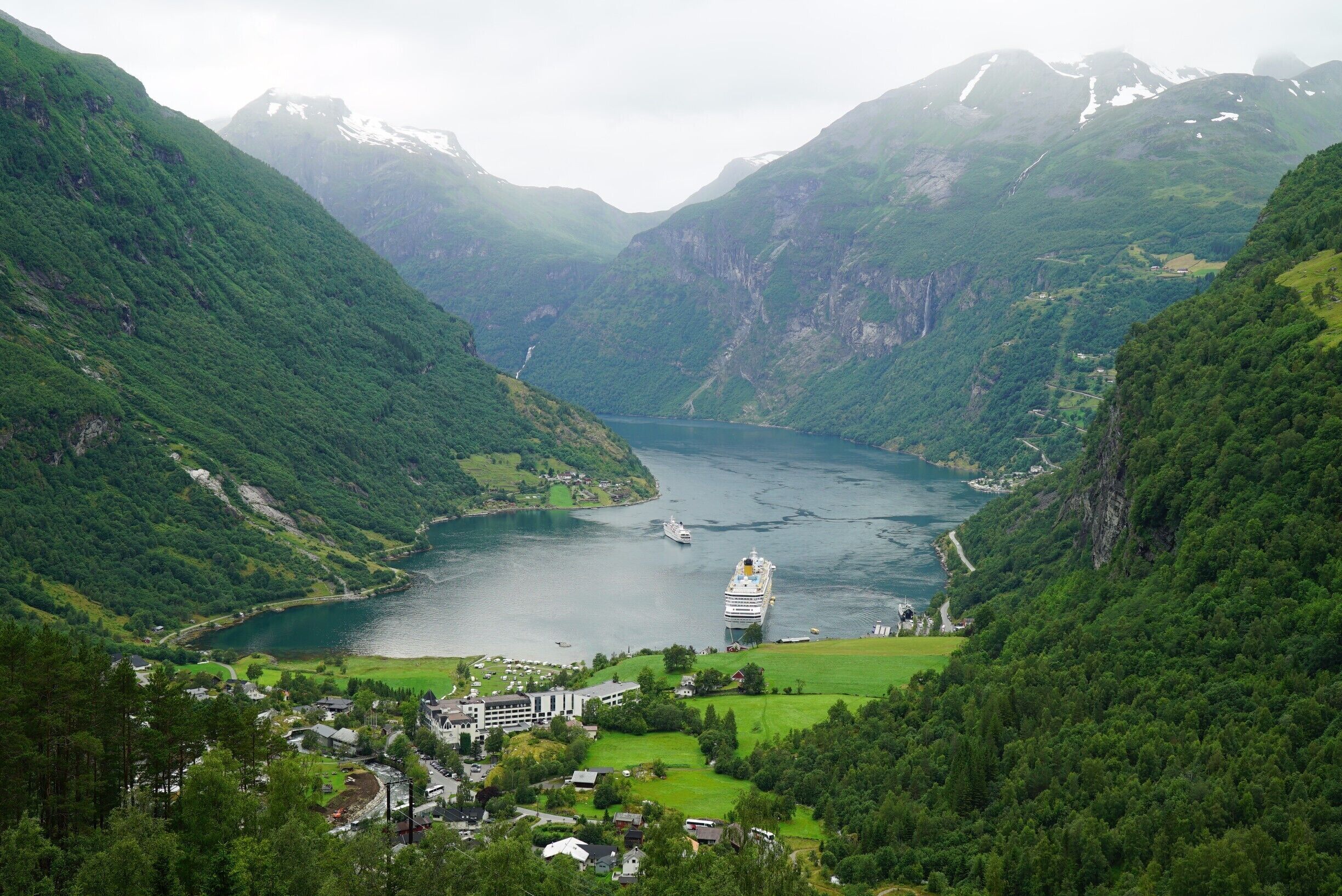 The small town of Geiranger at the end of a beautiful fjord being visited by a Costa Cruise Line ship.