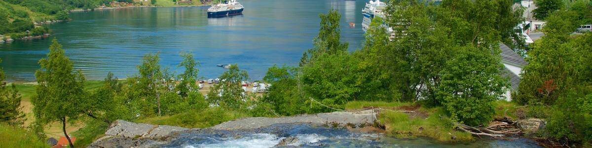 A river flowing through a mountainous landscape with a cruise ship in the background.