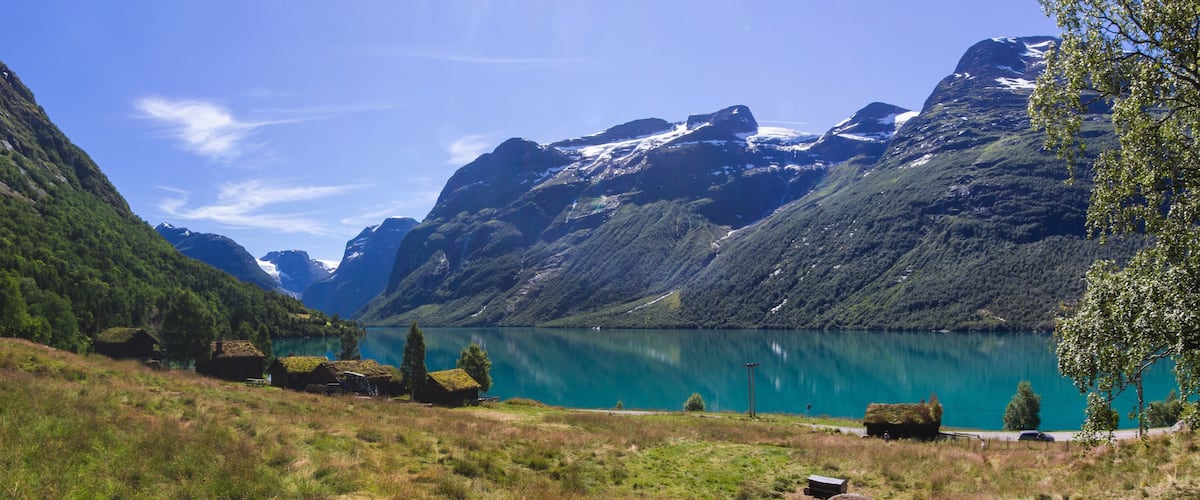 A mountain lake with green hills and a clear sky.