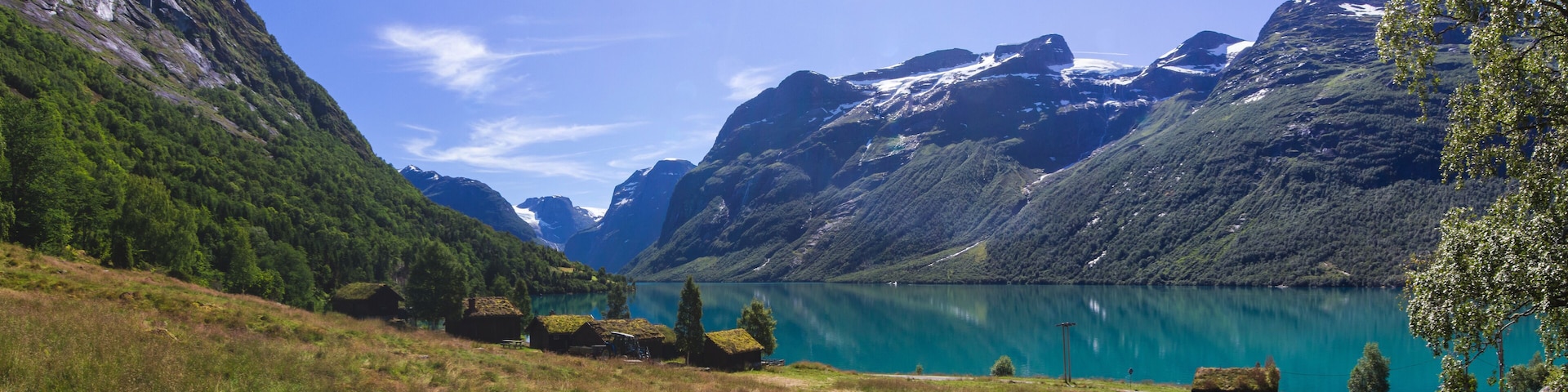 A mountain lake with green hills and a clear sky.