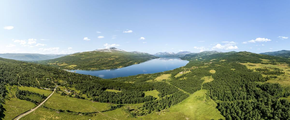 A lake surrounded by forested hills and mountains.