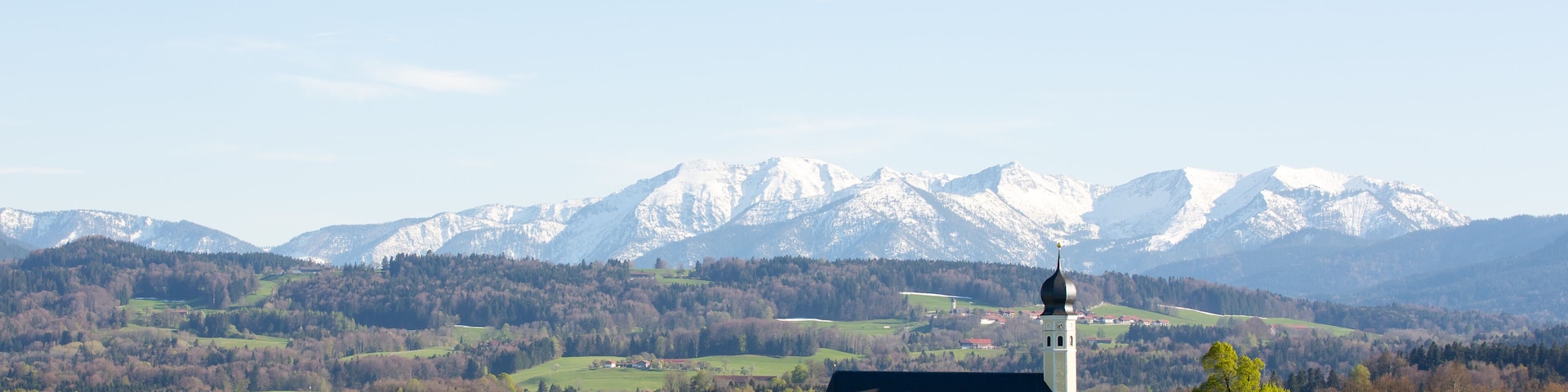 Landscape in Bavaria, Germany, church with mountains in the background