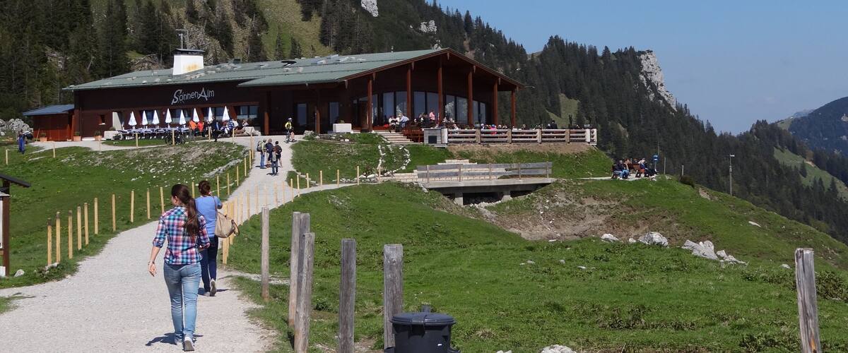 A mountain lodge with a wooden exterior and a view of a rocky mountain in the background.