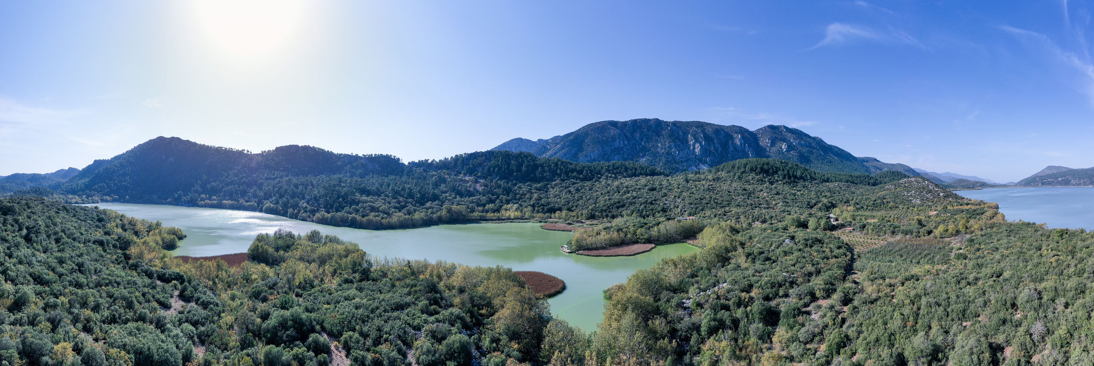 A lake surrounded by dense forest and mountains.