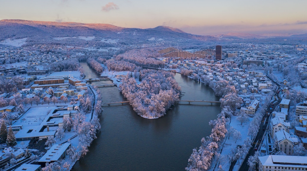 Aerial view of the snowy Zurlinden island on the Aare river in Aarau, Switzerland, with the Telli district and Gisliflue mountain at sunset