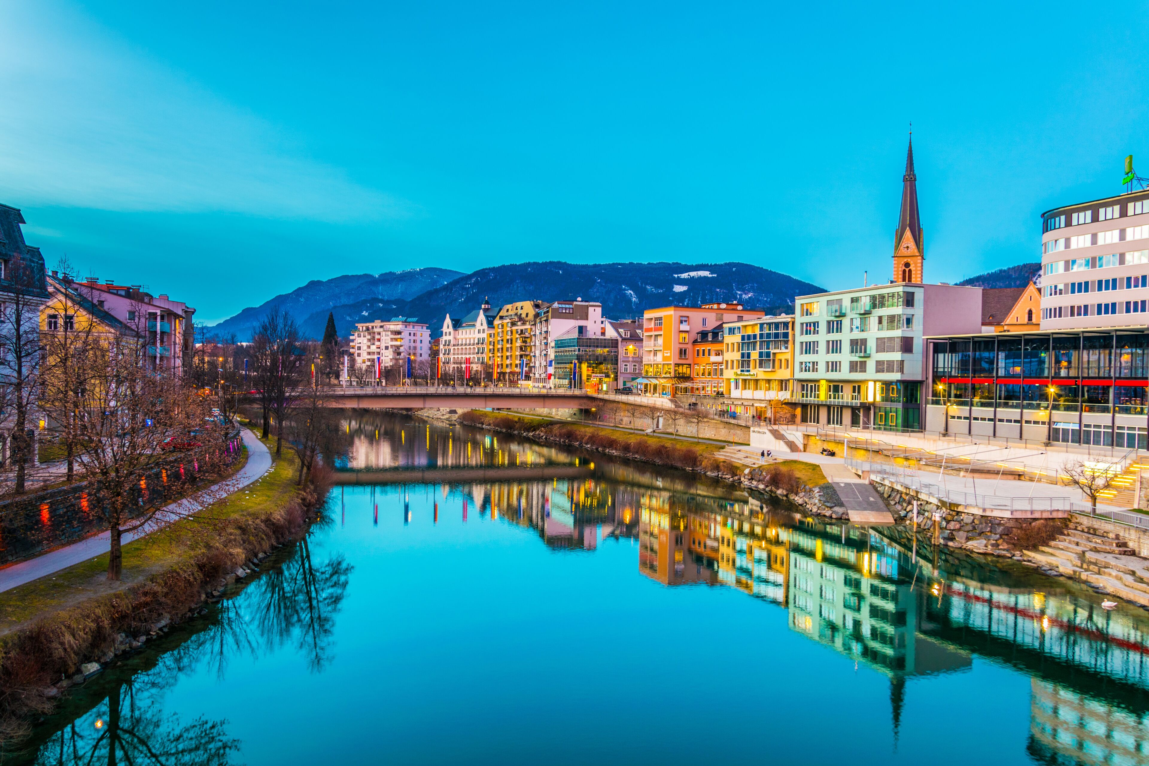 view of a riverside of river Drau during sunset in Villach, Austria