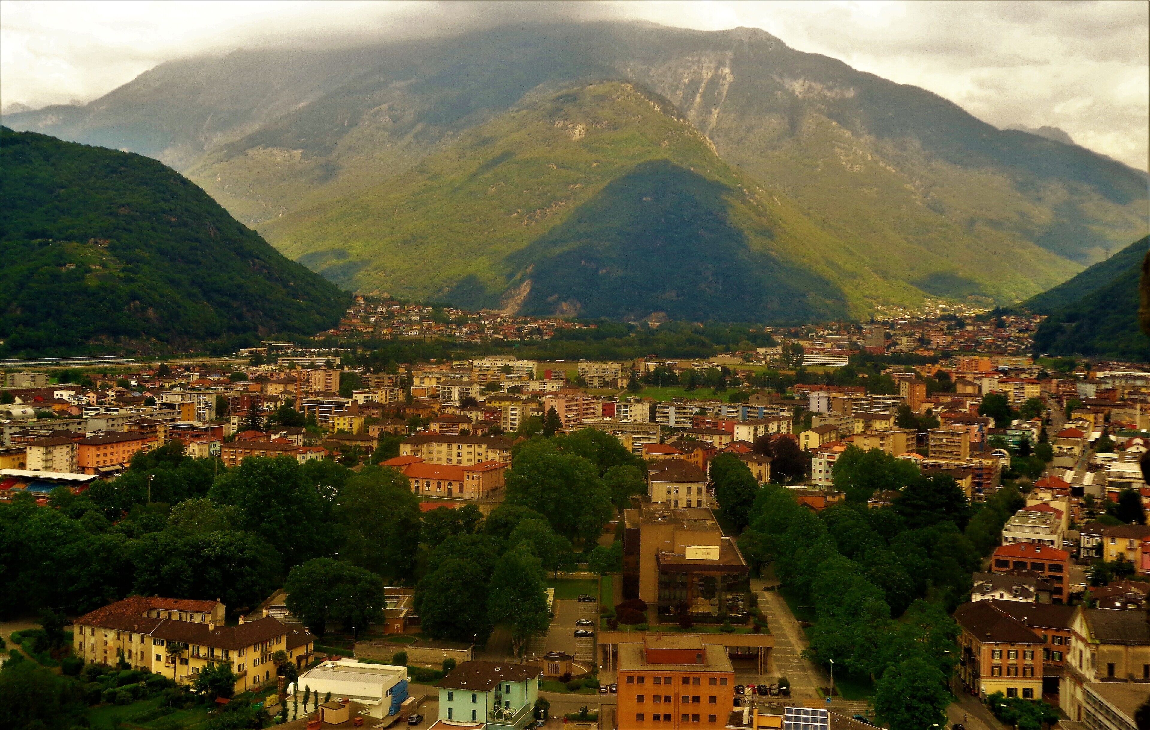 I took this photo from Castelgrande, one of the 3 castles in Bellinzona, Switzerland. Bellinzona is the capital of the Italian-speaking canton of Ticino and it's a great place to see castles and mountains! I was lucky to be there on the same day as an annual medieval fest! This was in May 2016 so the weather was quite nice! And the mountains and trees were so green! This was one of the most spectacular viewpoints in Bellinzona :). I loved those tree-lined lanes! And the epic mountain views!