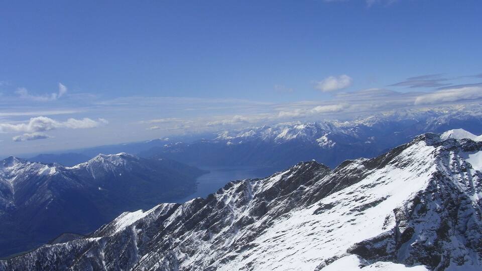 A snow-covered mountain range with a clear blue sky.