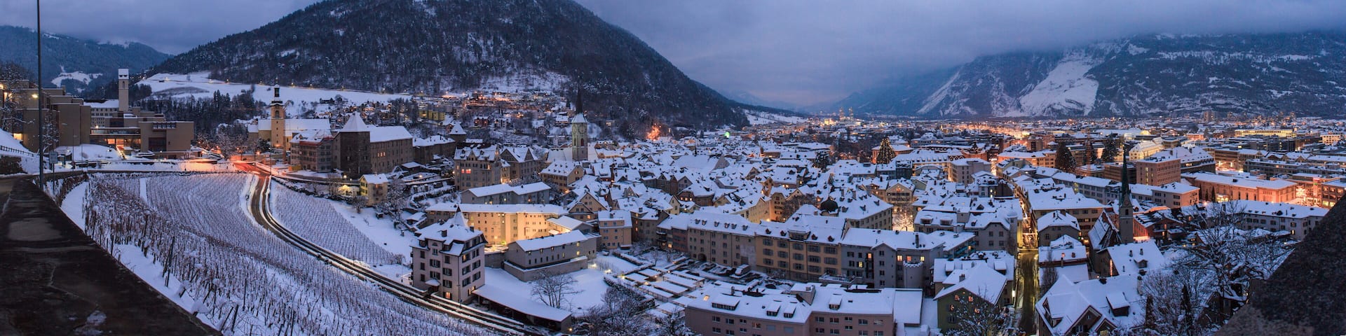 A snow-covered town with a prominent mountain in the background.