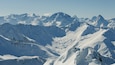 A snow-covered mountain range with sharp peaks and deep valleys.