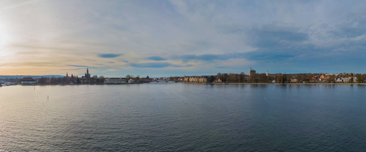 A river with a bridge, a city skyline, and a tower in the distance.