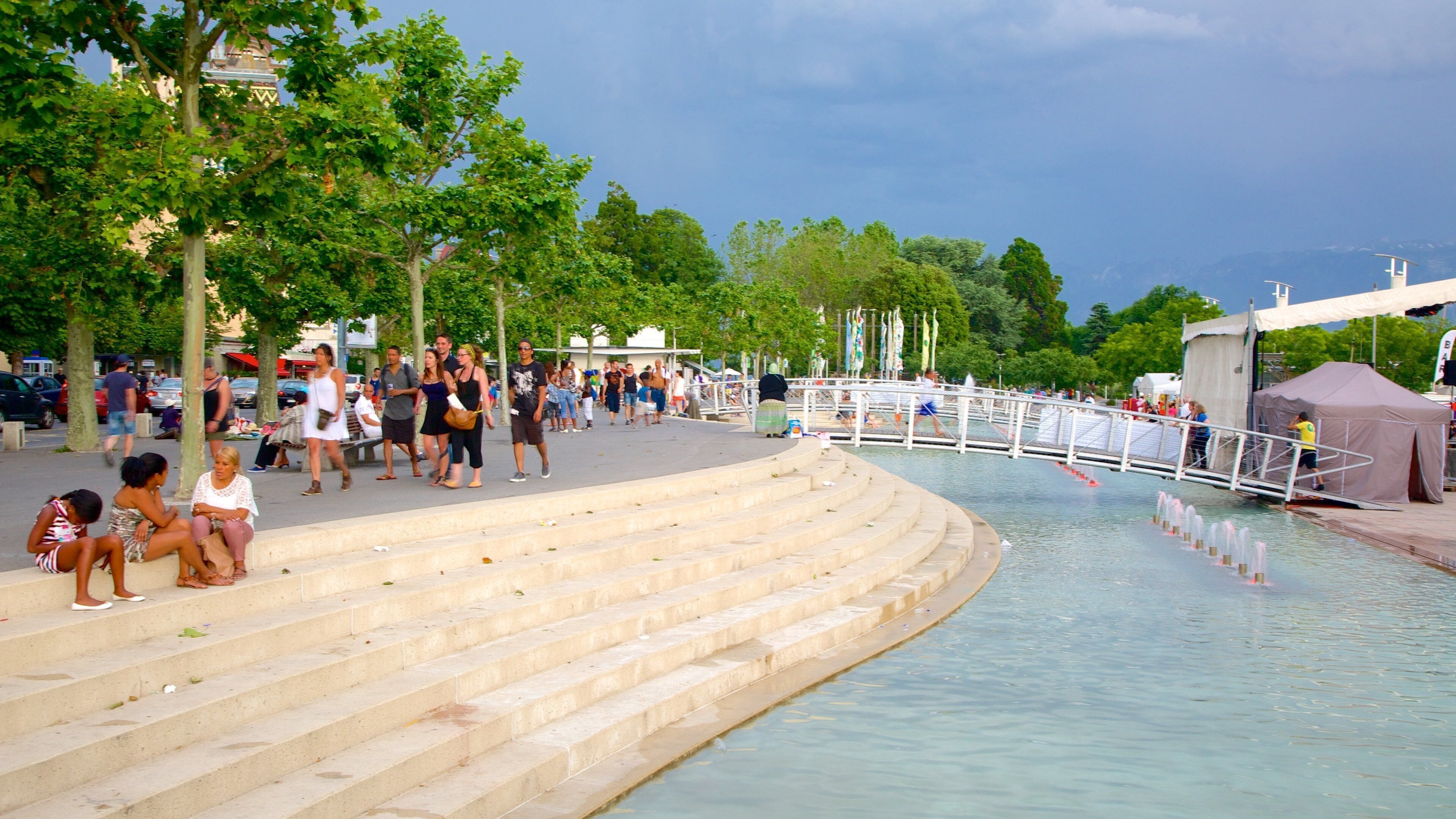 Lausanne showing a square or plaza and a pond as well as a large group of people
